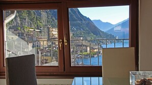 Una habitación con un ventanal grande que ofrece vistas a un paisaje montañoso y una masa de agua.