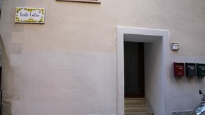 La entrada de un edificio con un cartel que dice 'Vicolo Gelso' y un buzón.