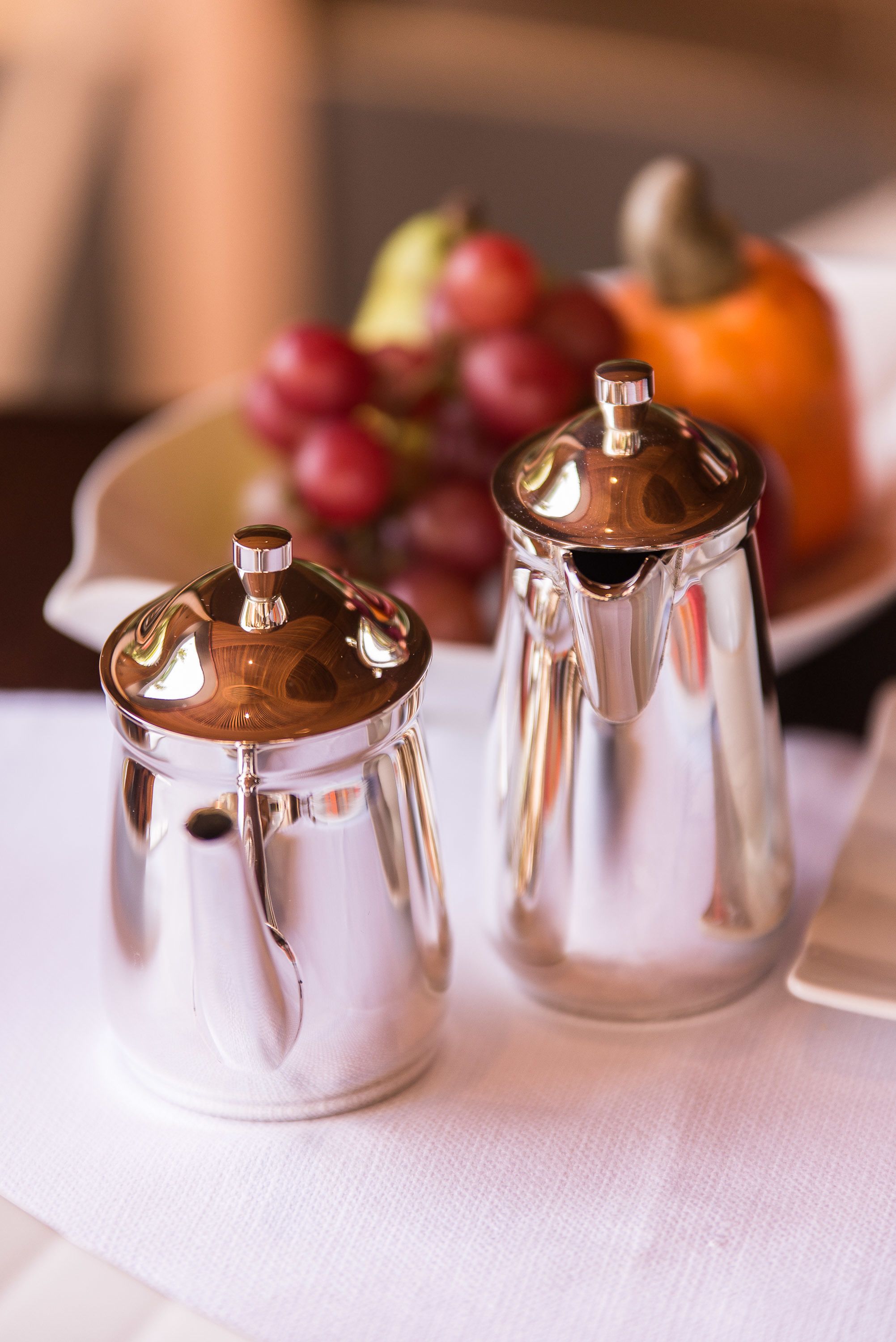 Zwei metallische Salz- und Pfefferstreuer auf einer weißen Tischdecke.