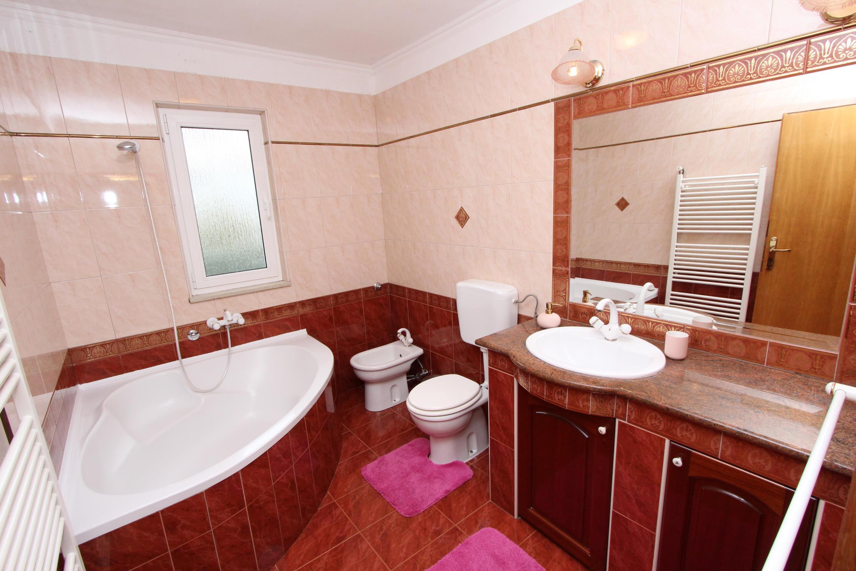A bathroom with a bathtub, toilet, and sink.
