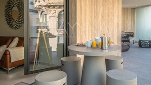 A modern living room with a round table set for breakfast, a sofa, and a large mirror on the wall. - Boutique 2 bedroom apartment VRBO (Nice)