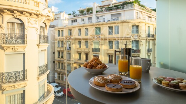 A balcony with pastries, a coffee maker, and orange juice glasses. - Boutique 2 bedroom apartment VRBO (Nice)
