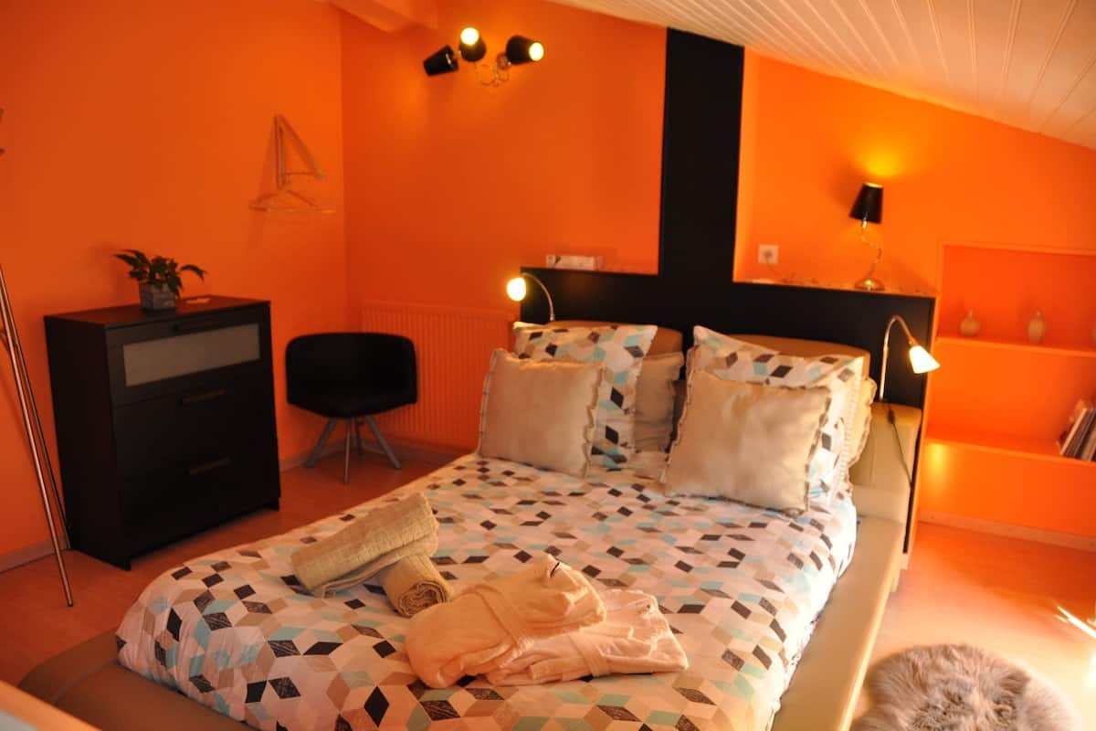 Une chambre à coucher avec un lit, des tables de chevet, une commode et une chaise.