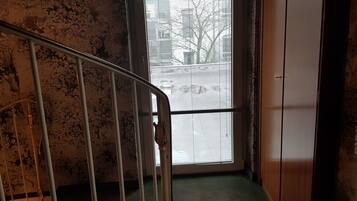 A staircase with a metal railing leading to a room with a large window.