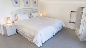 A bedroom with a bed, nightstands, and a wardrobe. - Villa 10 (Knysna)