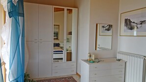 A bedroom with a wardrobe, a dresser, a mirror, and a framed picture on the wall. - Holideal Villa Cinzia (Solofra)
