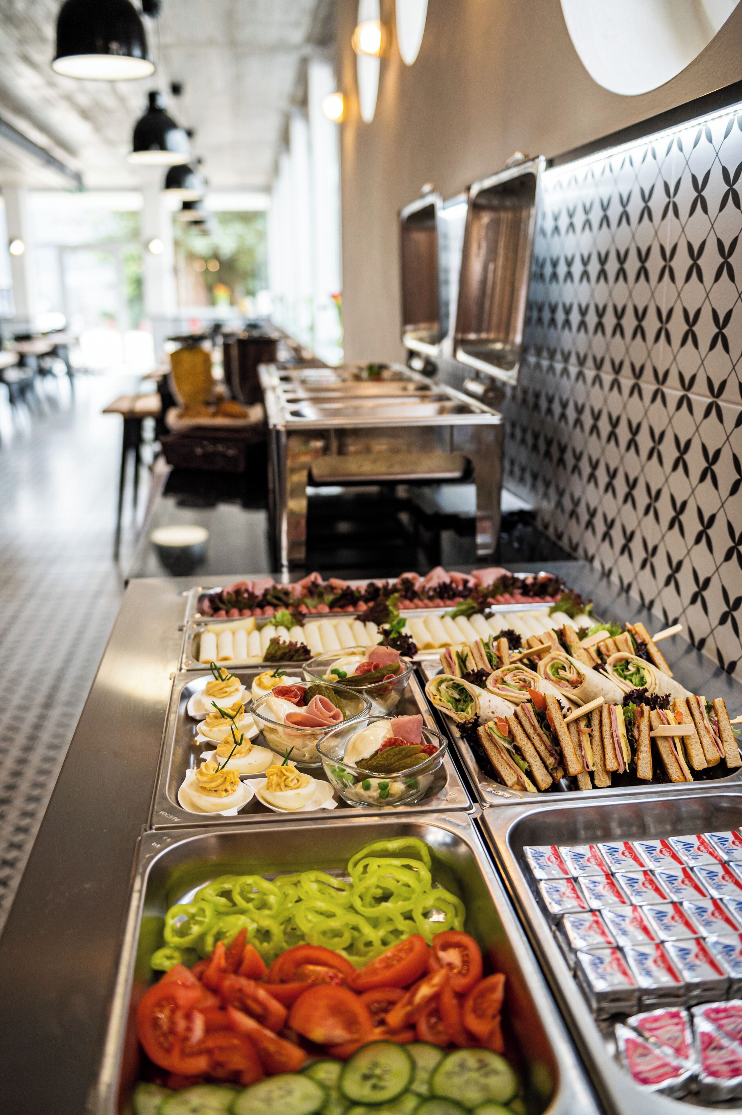 A buffet with various food options including sandwiches, salads, and dips.