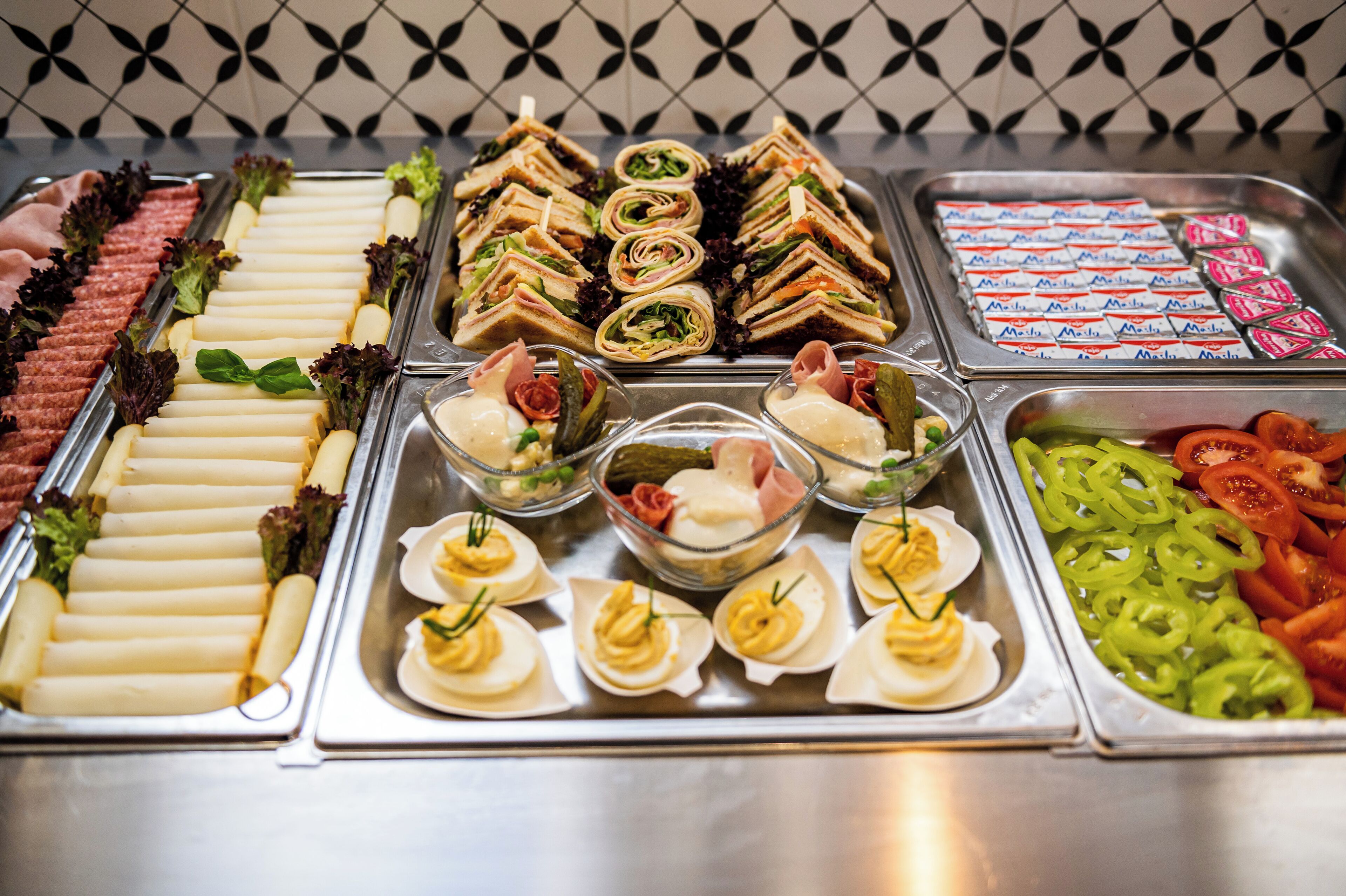 A buffet with various food items including sandwiches, salads, and appetizers.