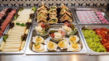 A buffet with various food items including sandwiches, salads, and appetizers.