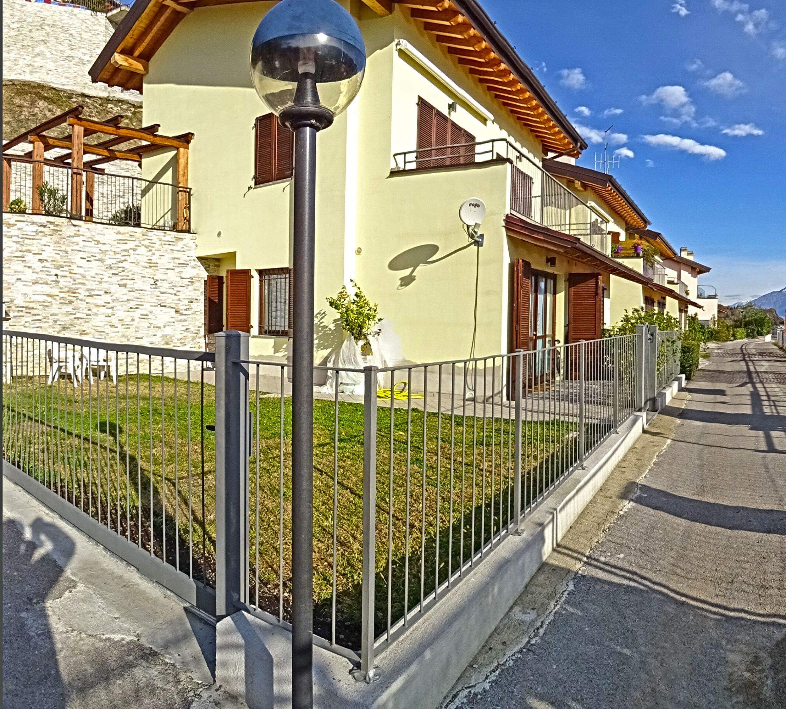 A residential building with a stone facade, a balcony, and a satellite dish.