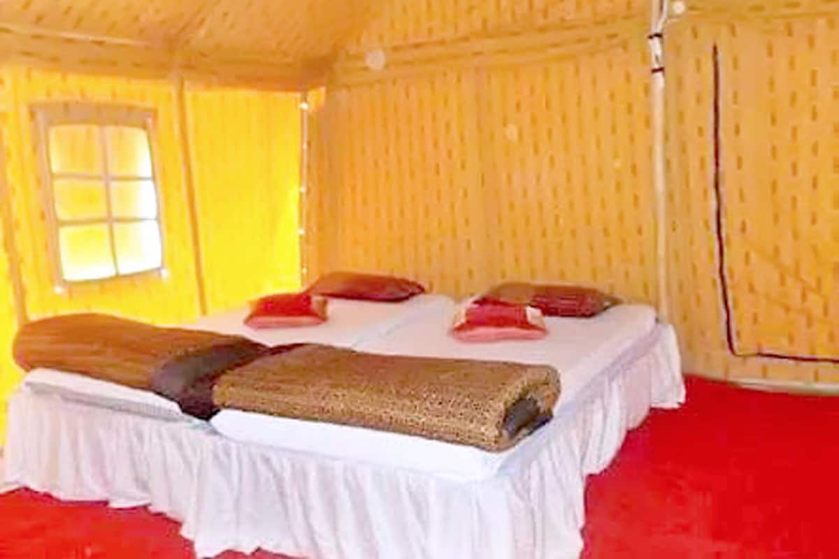 Um quarto com cama, travesseiros e janela.