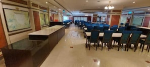 A spacious restaurant with a long counter and multiple seating areas.