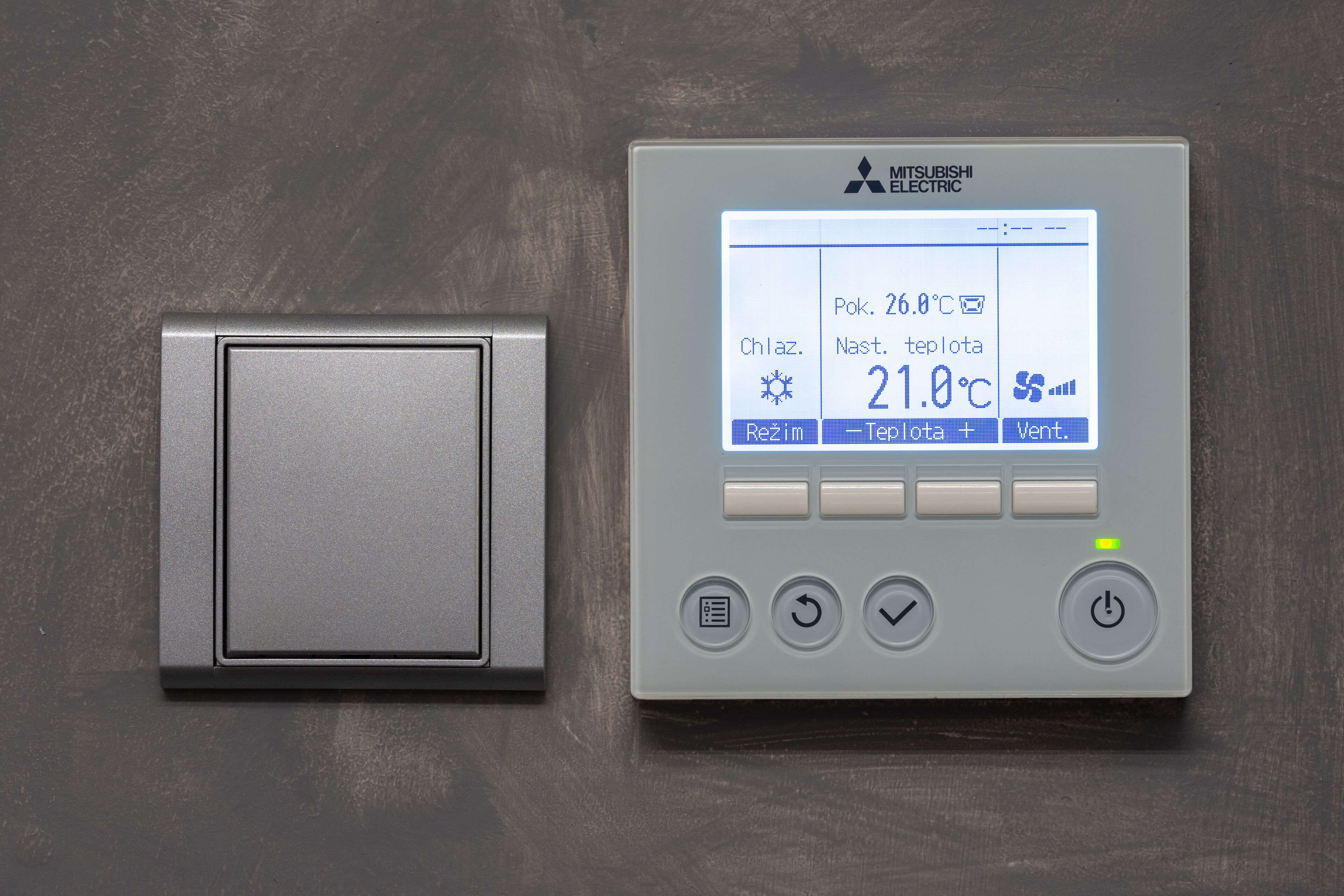 A thermostat with a digital display, control buttons, and a power button.
