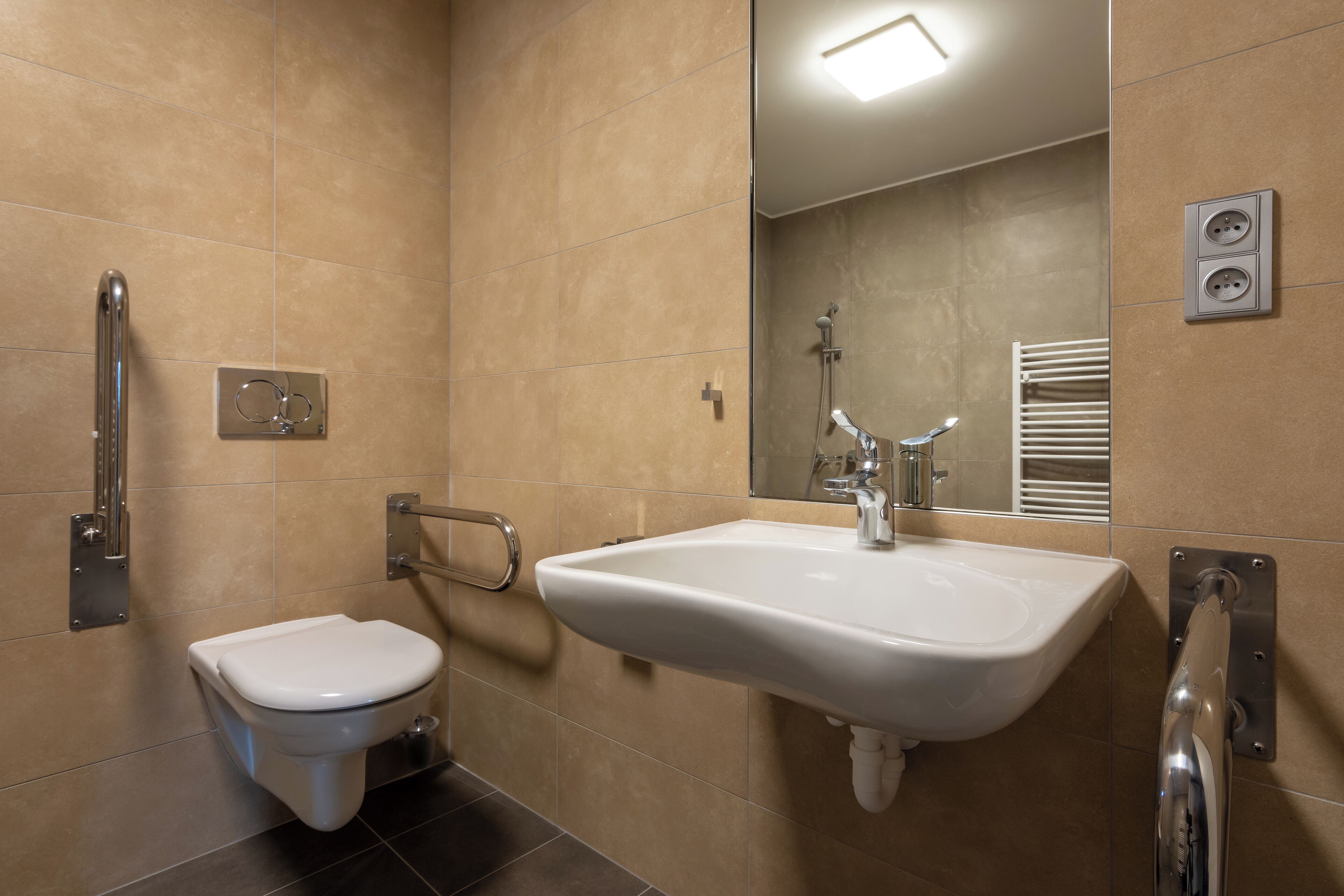 A modern bathroom with a white toilet, a sink with a mirror above it, and a shower area.