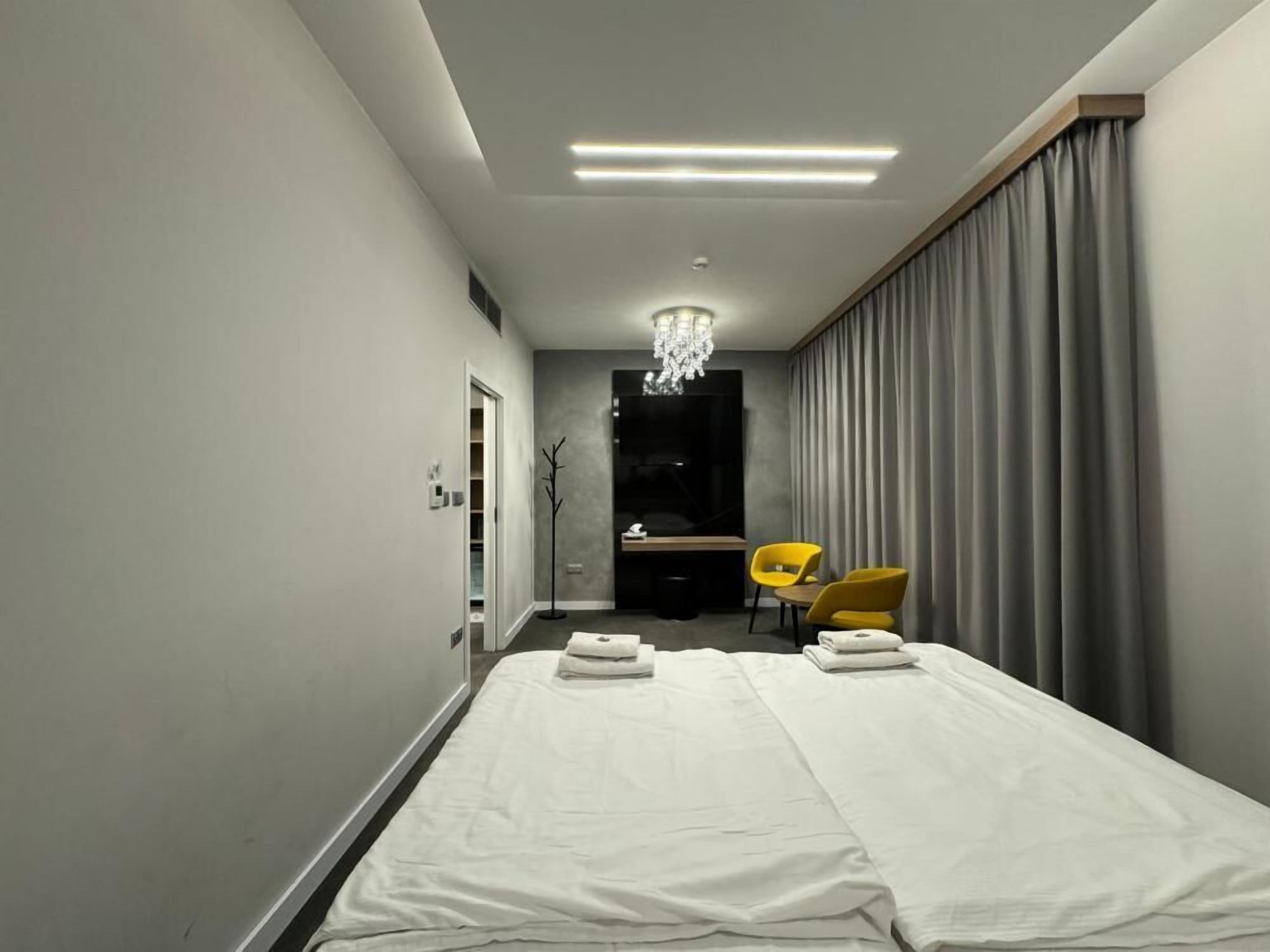 Habitación de hotel con cama, escritorio, silla y candelabro.