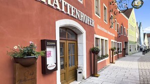A row of traditional European buildings with "SCHAFFENHOFER" signage, indicating a hotel or guesthouse.