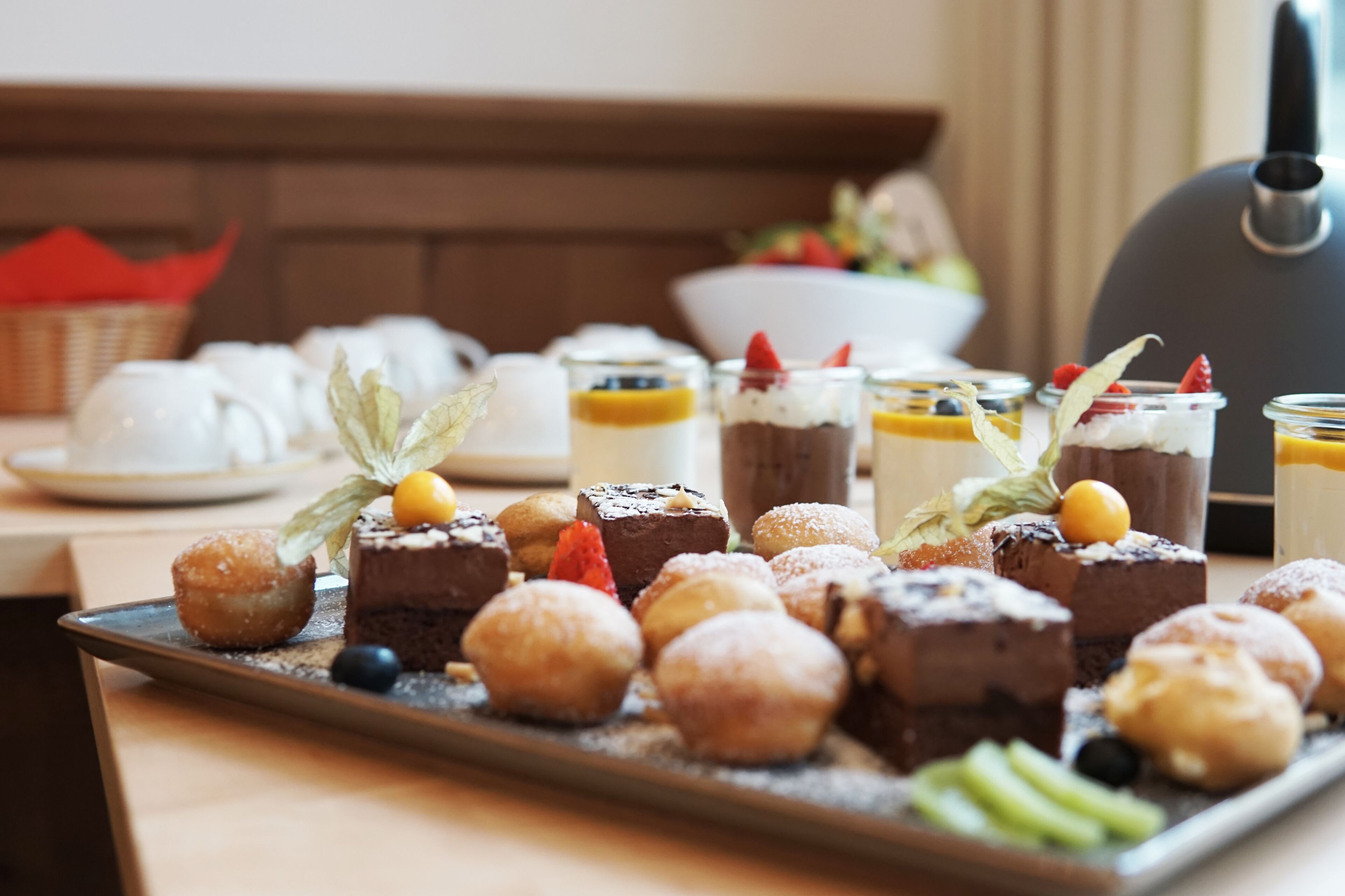 Un vassoio con una varietà di dolci, tra cui torte, pasticcini e guarnizioni di frutta.
