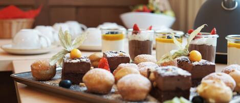 Un vassoio con una varietà di dolci, tra cui torte, pasticcini e guarnizioni di frutta.