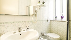 Une salle de bain avec un grand lavabo, des toilettes et un miroir.
