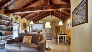 A cozy living room with a sofa, a bookshelf, and a dining area with a table and chairs.