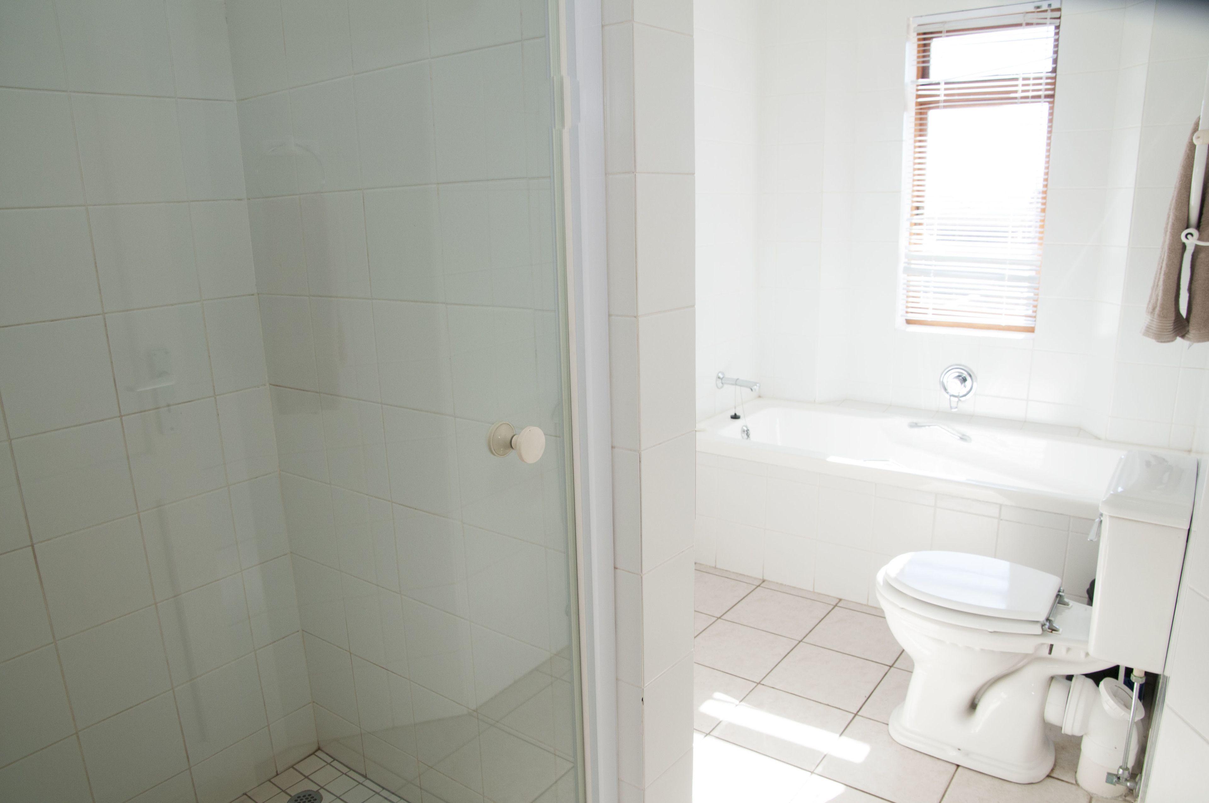A bathroom with a shower, toilet, and bathtub.