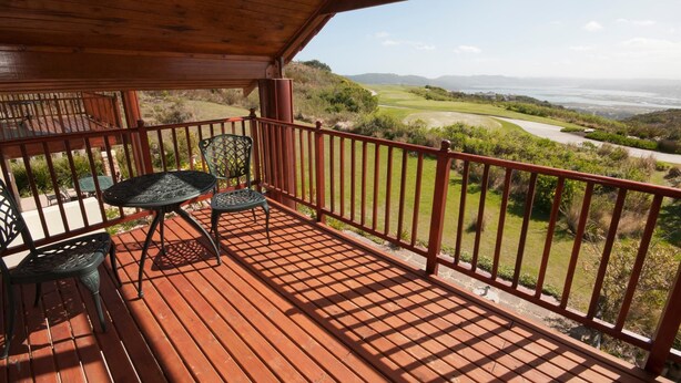 A wooden deck with a view of a golf course. - Villa 17 (Knysna)