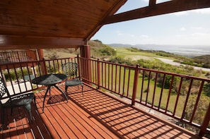 A wooden deck with a view of a golf course. - Villa 17 (Knysna)