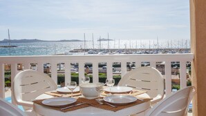 A table set for dining with a view of a marina and boats.