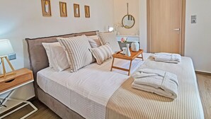 A neatly arranged bedroom with a bed, bedside table, and a bedside lamp. - Casa Luna Apartment,mini pool, Full Facilities (Rethymno)