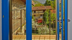 A blue door leading to a balcony with a mountain view. - Rustico Colonna (Tremosine)