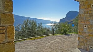 A stone pathway leading to a scenic overlook with a view of a lake and mountains. - Villa Vagne Holideal (Tremosine)