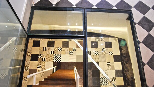 A staircase with a checkered floor pattern and a glass railing. - Just 50 meters from one of the most beautiful and renowned beaches of the Ragusa’s coas (Marina di Ragusa)