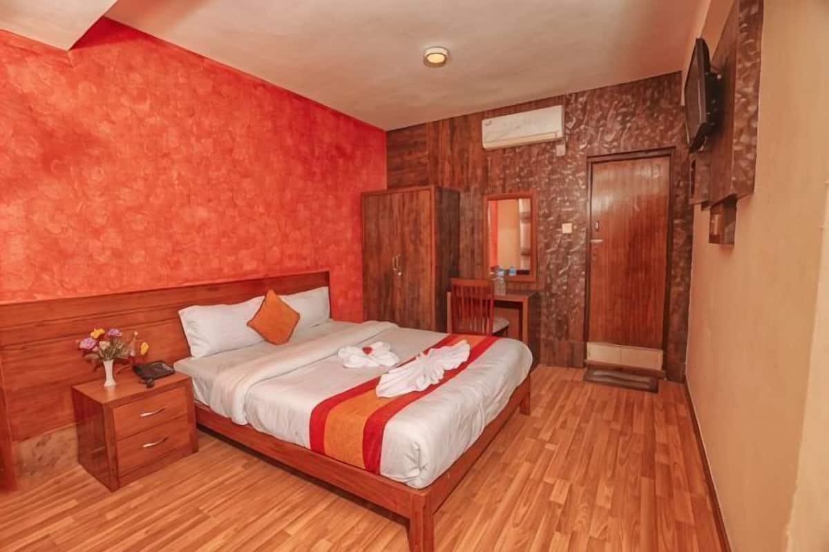 A bedroom with a wooden bed, a nightstand, a wardrobe, and a mirror.