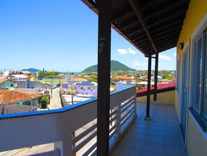 A balcony with a view of a town and mountains. - Pousada Atlântico II (Florianópolis)
