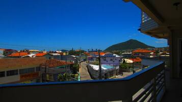 Un balcón con vista a un pueblo, edificios y una montaña al fondo.