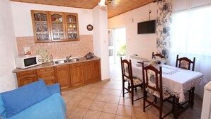 Uma cozinha com armários de madeira, micro-ondas e área de jantar com mesa e cadeiras.