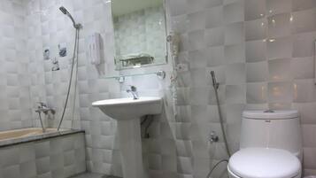 Een badkamer met een wit wastafel, toilet en douche.