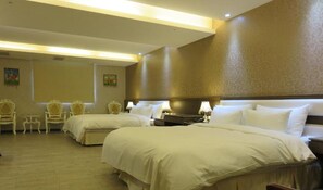 Habitación de hotel con dos camas, una mesita y dos sillas.