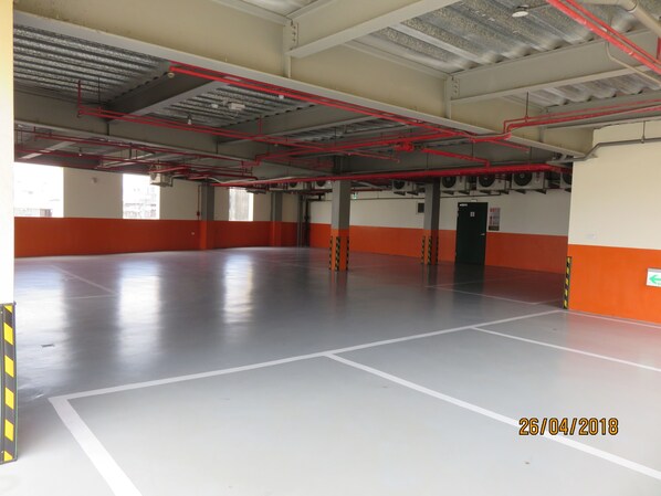 An empty parking garage with red pipes and a date stamp of 26/04/2018.