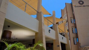 Un hotel con un diseño arquitectónico moderno, que cuenta con una entrada destacada con un gran toldo y el letrero visible del Hotel Gasaro.