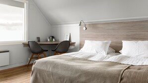 A bedroom with a bed, a desk, and a chair. - Vík Cottages (Vik I Myrdal)