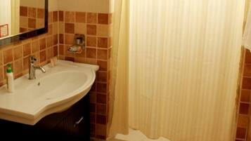A bathroom with a sink, mirror, and tiled walls.
