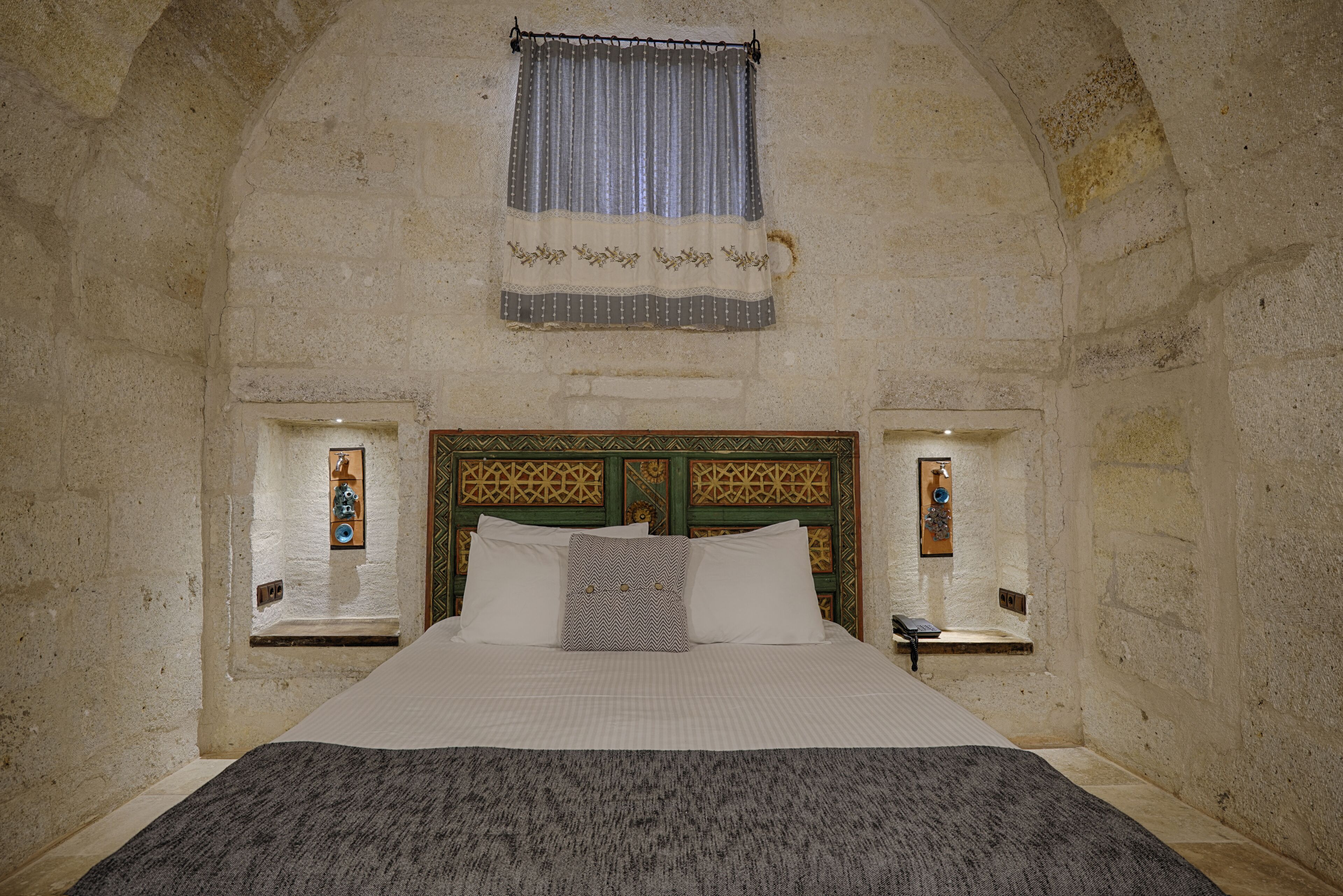 A bedroom with a large bed, a wooden headboard, and two bedside tables with lamps.