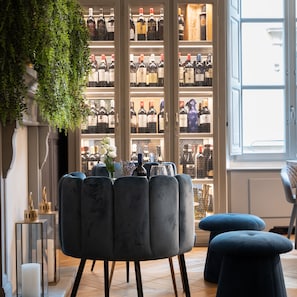 Ein modernes Interieur mit einer Sitzecke, einem Weinkühler und einem großen Fenster.