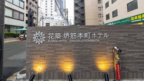 Ein Hotelschild mit einem floralen Logo und japanischen Schriftzeichen.