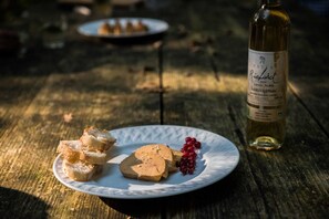 Une assiette remplie de nourriture et une bouteille de vin sur une table en bois.