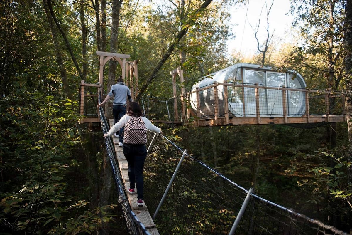 A suspension bridge with a glass enclosure on the right side.