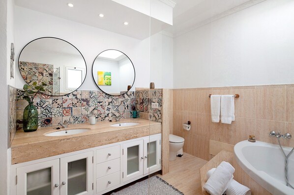 A modern bathroom with two sinks, a toilet, and a bathtub. - Air-Conditioned Villa with Luxurious Pool Area & Terrace Close to Golf Course (Costa Teguise)