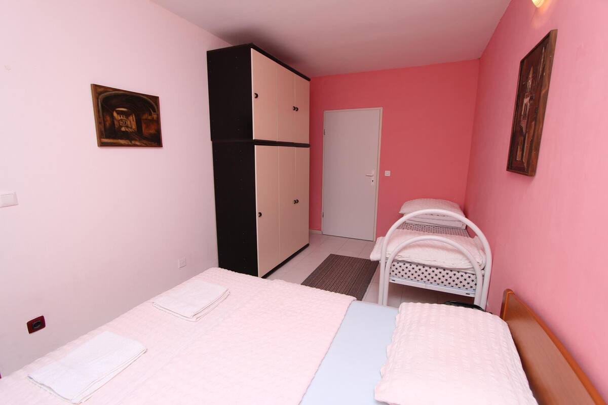 Ein Schlafzimmer mit zwei Betten, einem Kleiderschrank und einer Tür.