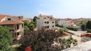 Un quartier résidentiel avec des immeubles à plusieurs étages, dont certains sont dotés de balcons, et un ciel dégagé.